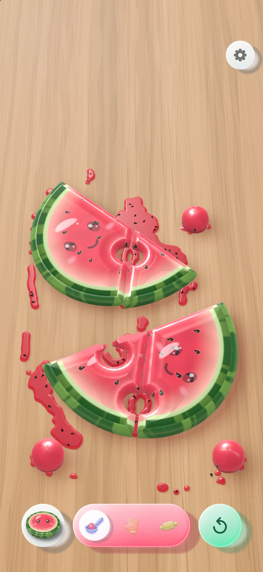 Two halves of a jelly watermelon on a honey wood board, with round holes scooped out of them and three jelly melon balls rolling beside them